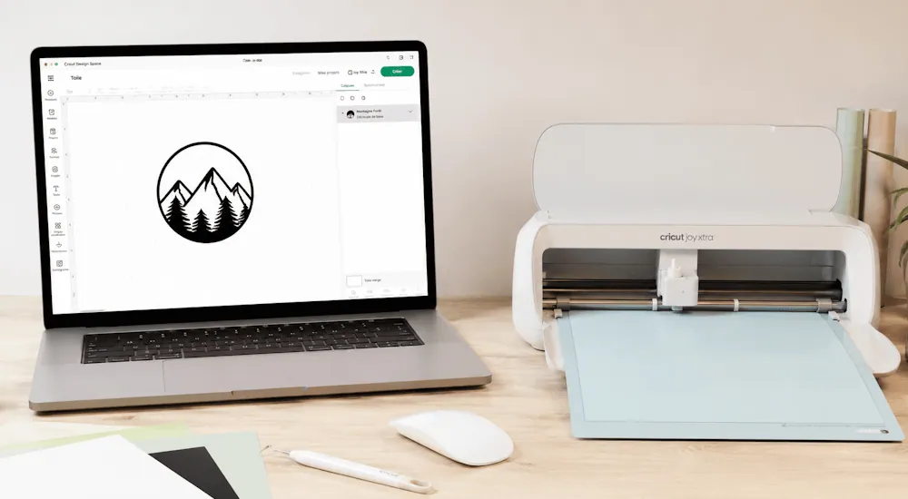 Logo montagne préparé dans Cricut Design Space sur un ordinateur portable, à côté d'une Cricut Joy Xtra