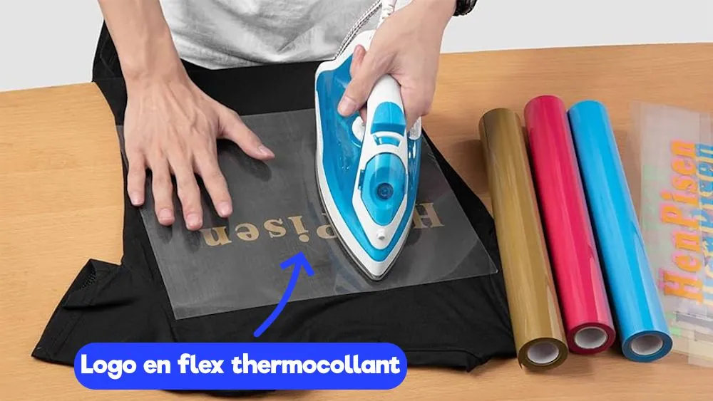 Logo en flex thermocollant doré repassé au fer sur un t-shirt noir, rouleaux de flex colorés à côté
