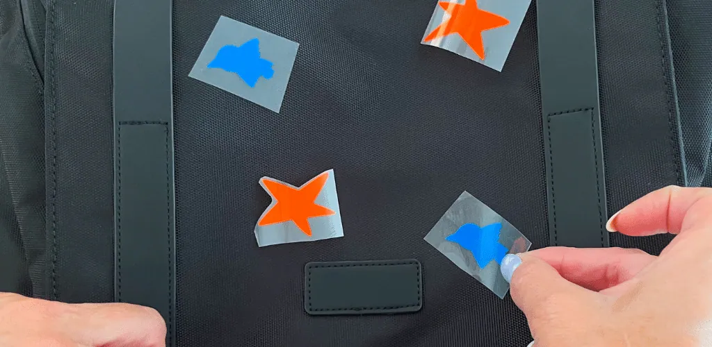 Positionnement d'étoiles orange et d'oiseaux bleus en flex sur le devant d'un cartable noir