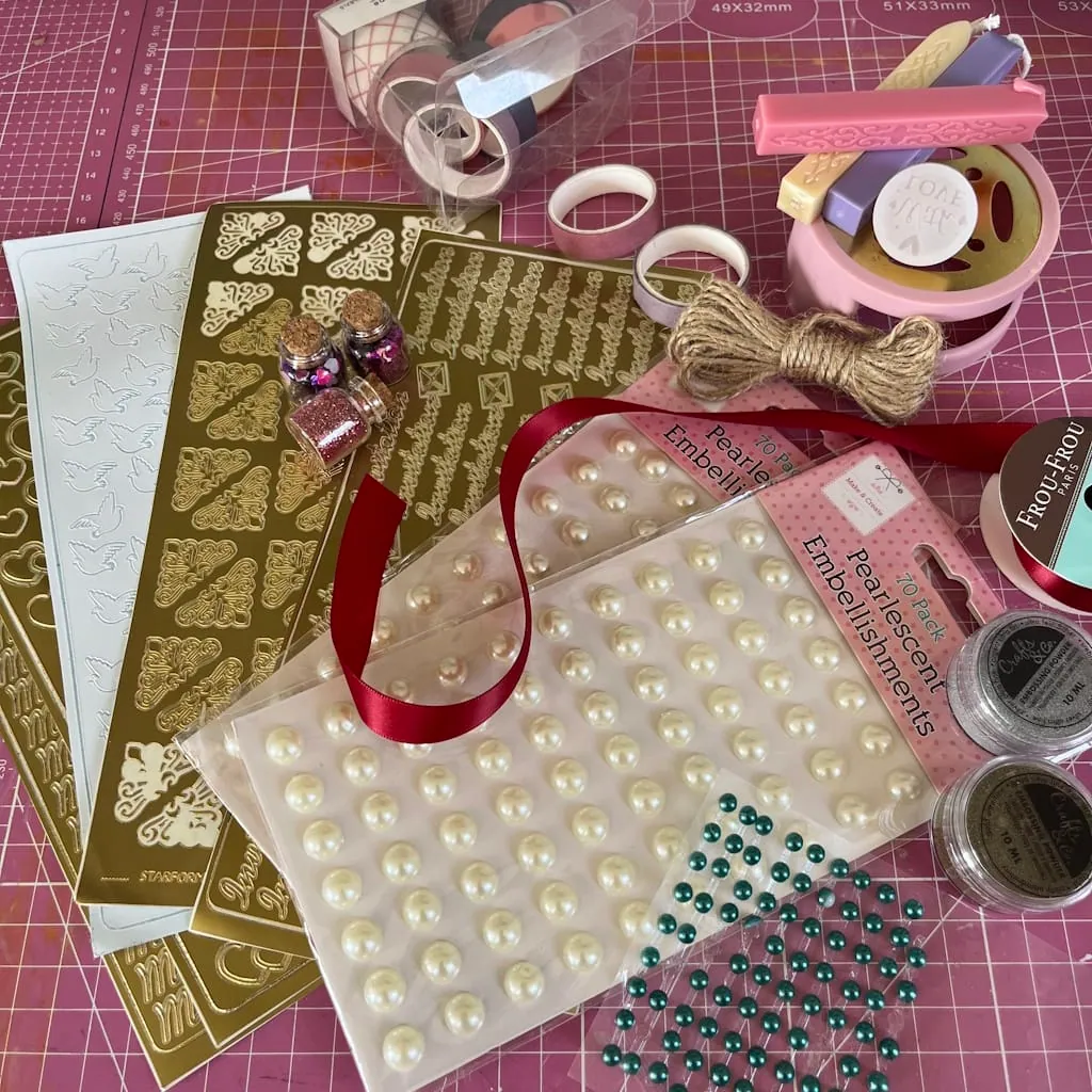 Embellissements pour faire-part : stickers dorés, demi-perles, ruban rouge, ficelle de jute et cire à cacheter