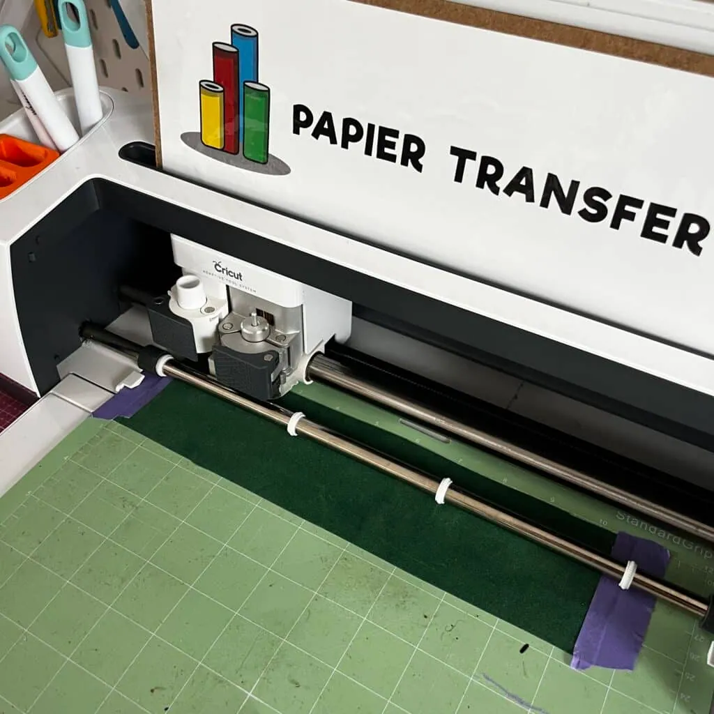 Cricut en train de découper du vinyle adhésif vert sur le tapis pour la boule de Noël