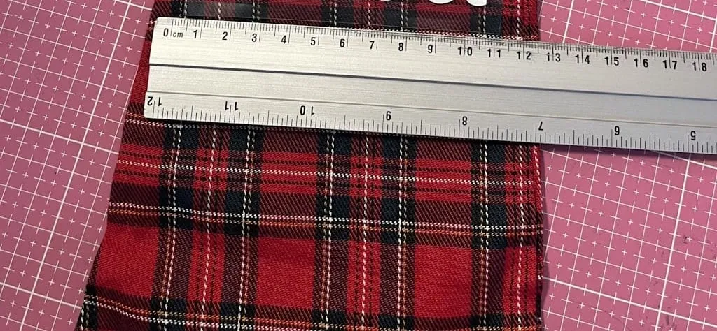 Chaussette de Noël en tartan rouge mesurée à la règle pour positionner le prénom