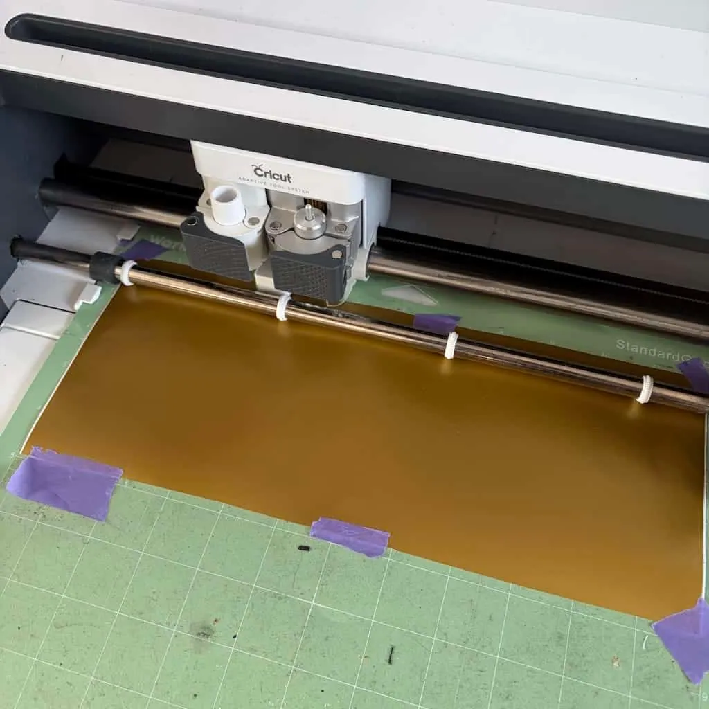 Cricut en train de découper du vinyle adhésif doré pour le carnet