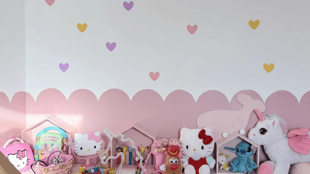 Chambre de fille : frise de festons roses et cœurs en vinyle adhésif au mur, étagère de peluches Hello Kitty